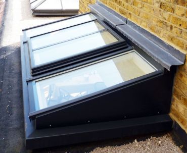 Pitched skylight abutting wall with double-pane opening vent