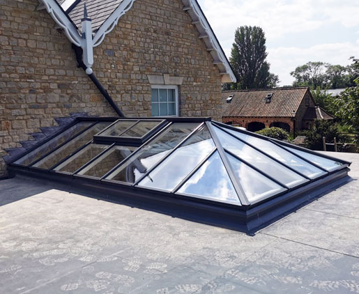 Photo of hipped roof lantern abutting house wall, with a non-standard two-pane vent