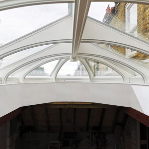 Photo showing the inside of an unusual solid wood lantern with curved rafters during installation in London